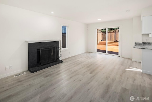 unfurnished living room featuring a fireplace, recessed lighting, visible vents, light wood-style floors, and baseboards