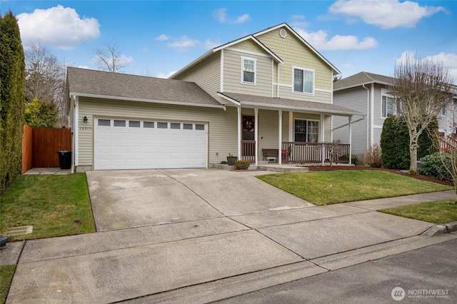 traditional-style home with concrete driveway, covered porch, fence, a garage, and a front lawn