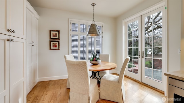 dining space with baseboards, french doors, and light wood-style floors