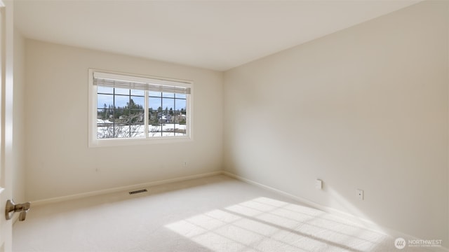 unfurnished room featuring light colored carpet, visible vents, and baseboards