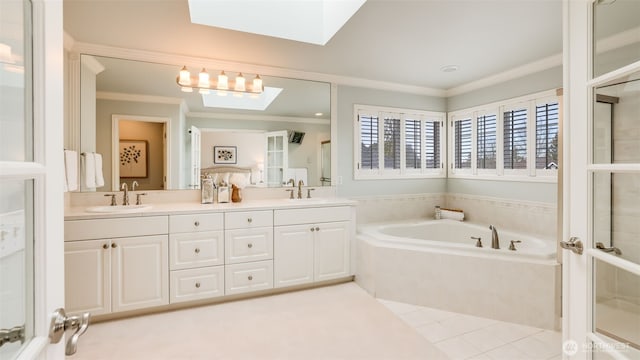 bathroom featuring double vanity, a skylight, a sink, and crown molding