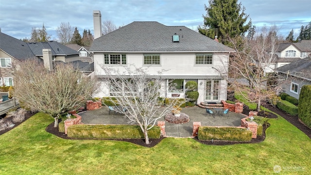 back of house with a patio, a chimney, and a lawn