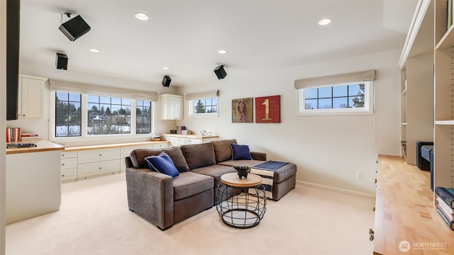 living area with baseboards, recessed lighting, and a healthy amount of sunlight