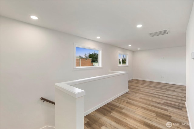 interior space featuring visible vents, an upstairs landing, recessed lighting, light wood-style floors, and baseboards