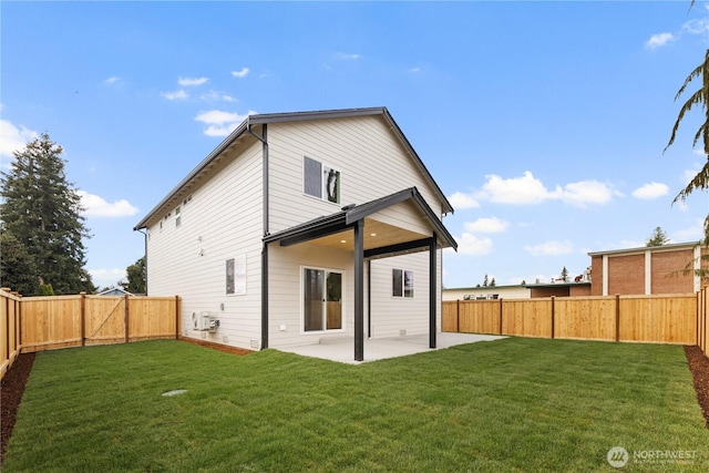 rear view of house featuring a patio, a lawn, and a fenced backyard