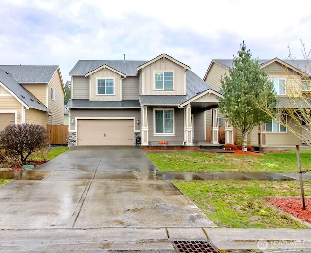 view of front of house featuring driveway, an attached garage, fence, a front lawn, and board and batten siding