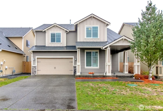 craftsman-style home with a garage, driveway, a shingled roof, and board and batten siding