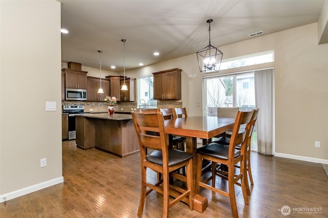 dining room with dark wood-style flooring, recessed lighting, visible vents, and baseboards