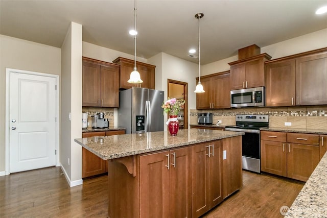 kitchen featuring tasteful backsplash, a kitchen island, appliances with stainless steel finishes, and dark wood finished floors