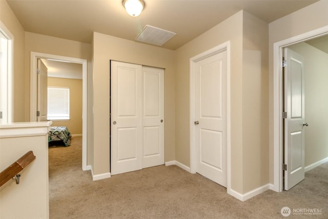 unfurnished bedroom with light carpet, baseboards, and a closet