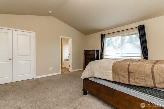 bedroom featuring lofted ceiling, light colored carpet, connected bathroom, and baseboards