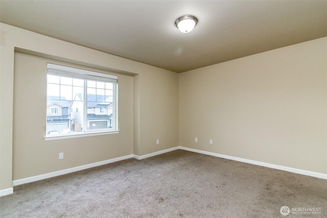 carpeted empty room with baseboards