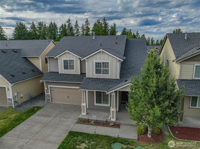 14426 99th Ave SE, Yelm, WA 98597 - craftsman-style house featuring board and batten siding, driveway, a shingled roof, a garage, and stone siding
