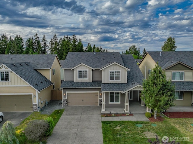 14426 99th Ave SE, Yelm, WA 98597 - craftsman house with board and batten siding, concrete driveway, stone siding, roof with shingles, and an attached garage