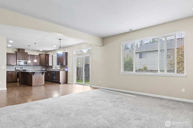 14426 99th Ave SE, Yelm, WA 98597 - kitchen featuring appliances with stainless steel finishes, open floor plan, a breakfast bar area, baseboards, and dark brown cabinets