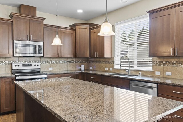 14426 99th Ave SE, Yelm, WA 98597 - kitchen featuring stainless steel appliances, a sink, backsplash, decorative light fixtures, and recessed lighting