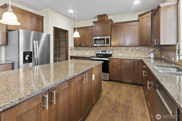 14426 99th Ave SE, Yelm, WA 98597 - kitchen with stainless steel appliances, a sink, dark wood-style flooring, decorative backsplash, and light stone counters
