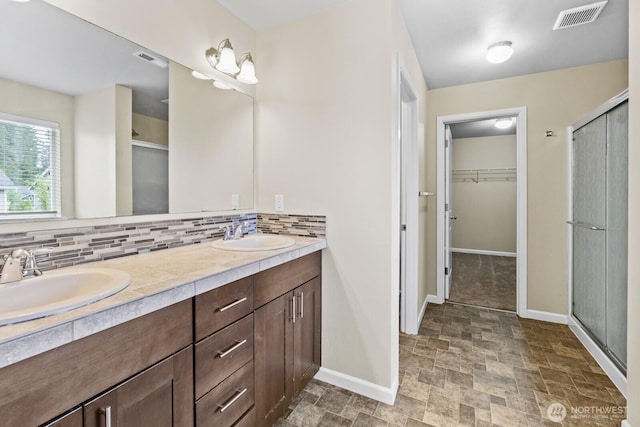 14426 99th Ave SE, Yelm, WA 98597 - bathroom featuring baseboards, a stall shower, tasteful backsplash, and double vanity