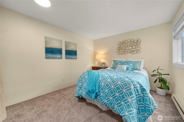 bedroom with carpet flooring, baseboard heating, and a textured ceiling