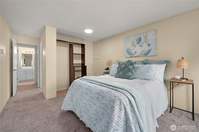 bedroom featuring a closet, light colored carpet, and a textured ceiling