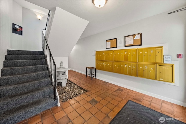 interior space with mail area, baseboards, and tile patterned flooring