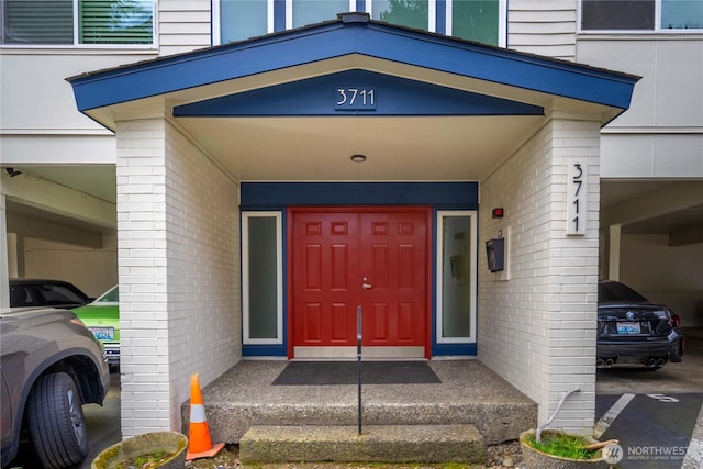 view of exterior entry featuring brick siding