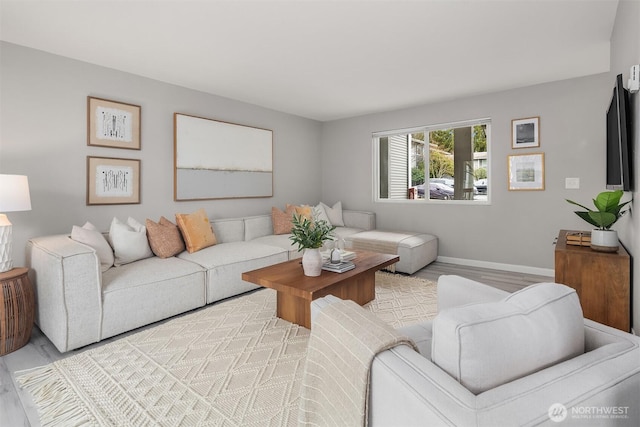 living area featuring baseboards and wood finished floors