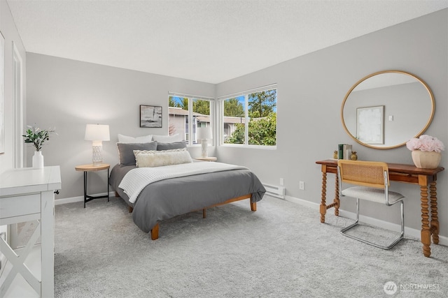 bedroom with baseboards, baseboard heating, and light colored carpet