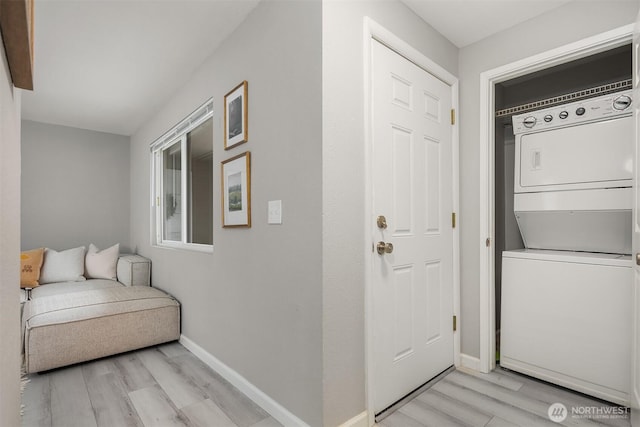 doorway to property featuring stacked washing maching and dryer