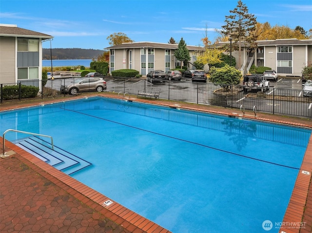 pool with a water view and fence