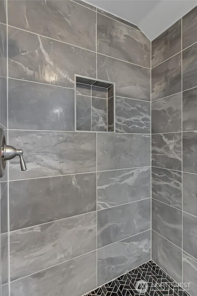 bathroom with a tile shower