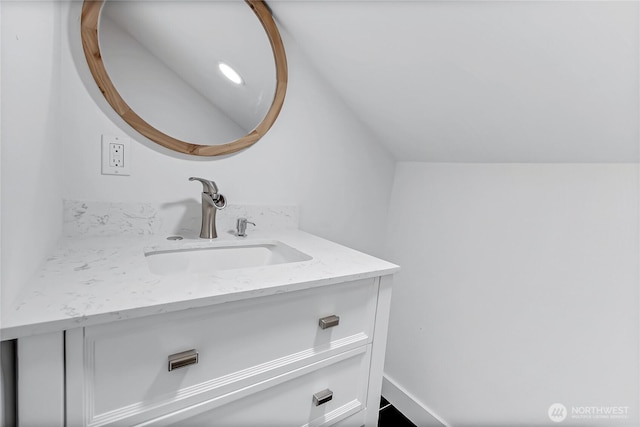 bathroom featuring vaulted ceiling and vanity