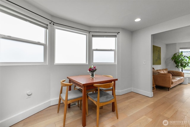 dining space with a wealth of natural light and light hardwood / wood-style floors