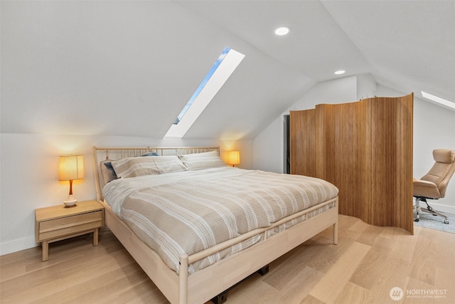 bedroom with light hardwood / wood-style flooring and lofted ceiling with skylight