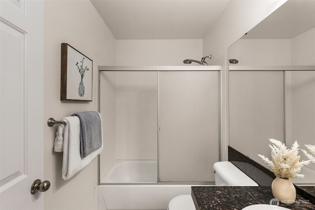 full bathroom featuring vanity, shower / bath combination with glass door, and toilet