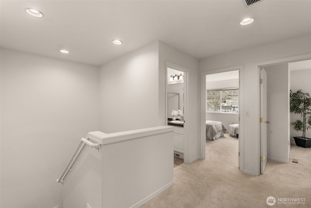 hallway featuring light colored carpet