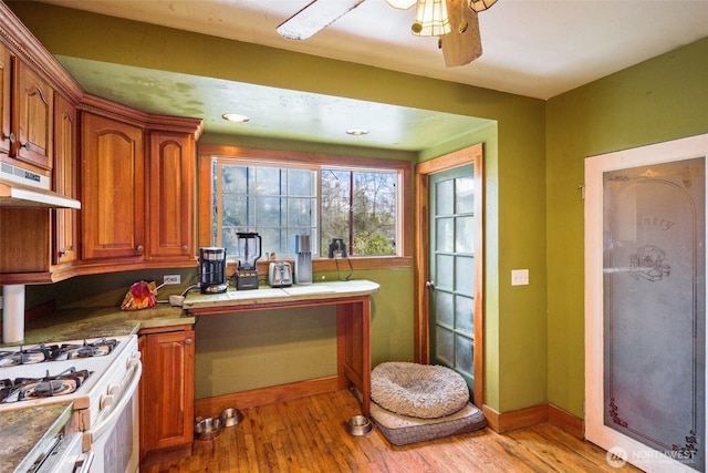 3416 Claremont Ave S, Seattle, WA 98144 - kitchen featuring light wood-type flooring, a ceiling fan, white range with gas stovetop, under cabinet range hood, and brown cabinetry