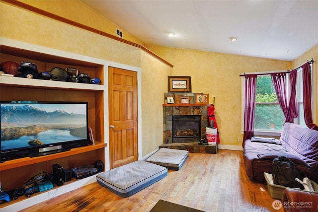 3416 Claremont Ave S, Seattle, WA 98144 - living area featuring visible vents, a stone fireplace, vaulted ceiling, hardwood / wood-style floors, and baseboards
