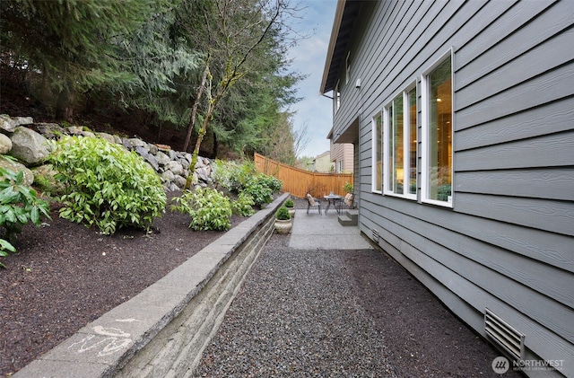 view of yard featuring fence, baseboard heating, and a patio