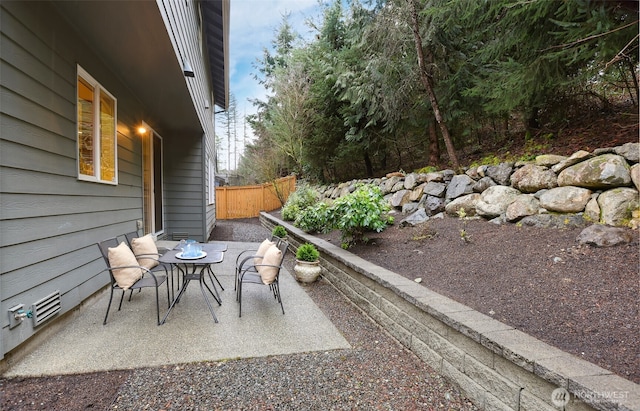 view of patio with outdoor dining space and fence