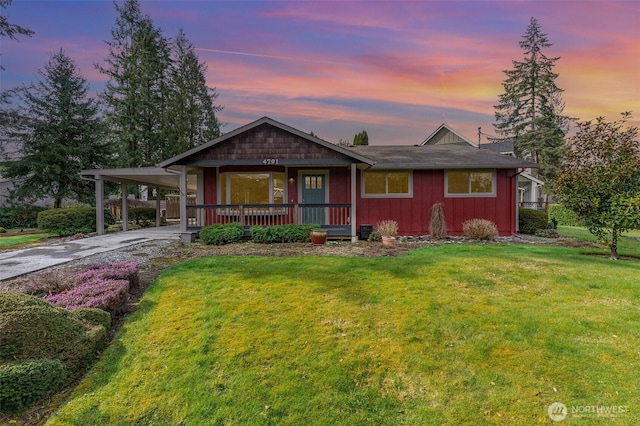 view of front of home featuring an attached carport, driveway, a porch, a lawn, and board and batten siding