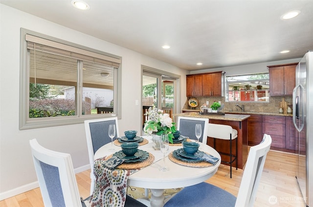 dining area with recessed lighting, a healthy amount of sunlight, light wood-type flooring, and baseboards