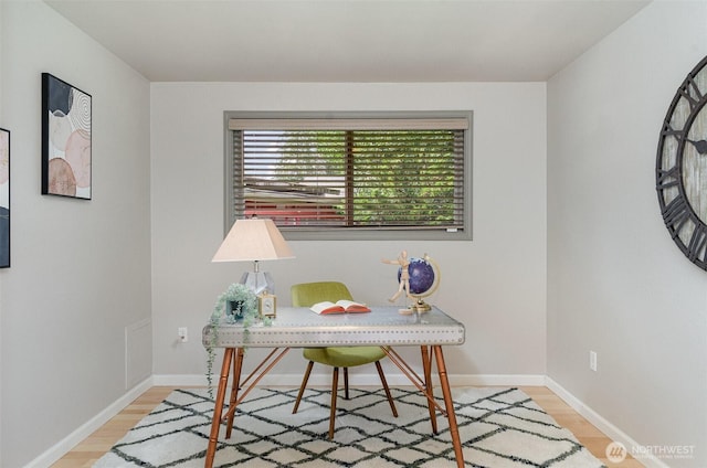 office area with baseboards and light wood-style flooring