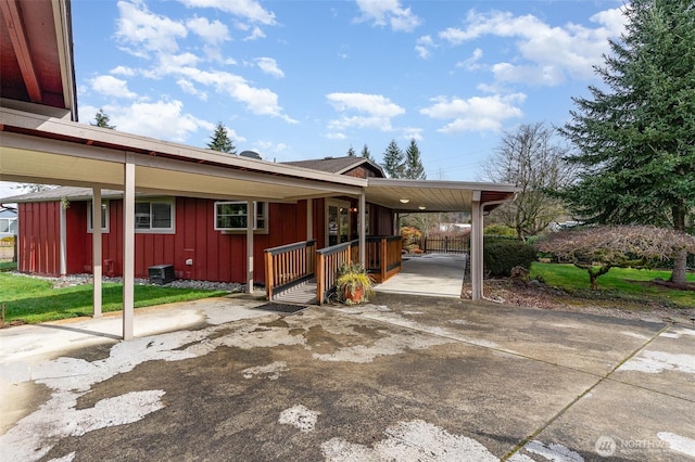 view of home's exterior featuring an attached carport, board and batten siding, and a lawn