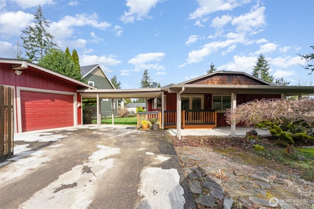 view of front of property featuring an attached carport, a porch, and driveway