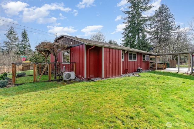 exterior space with ac unit, board and batten siding, a yard, and fence