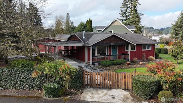 view of front of house with a fenced front yard, board and batten siding, and a porch