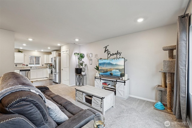 living area with recessed lighting, baseboards, and light colored carpet