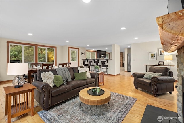 living room featuring baseboards, light wood-style flooring, and recessed lighting