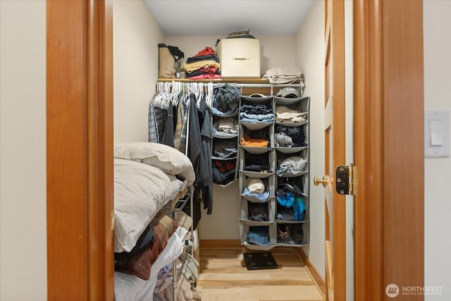 walk in closet with wood finished floors